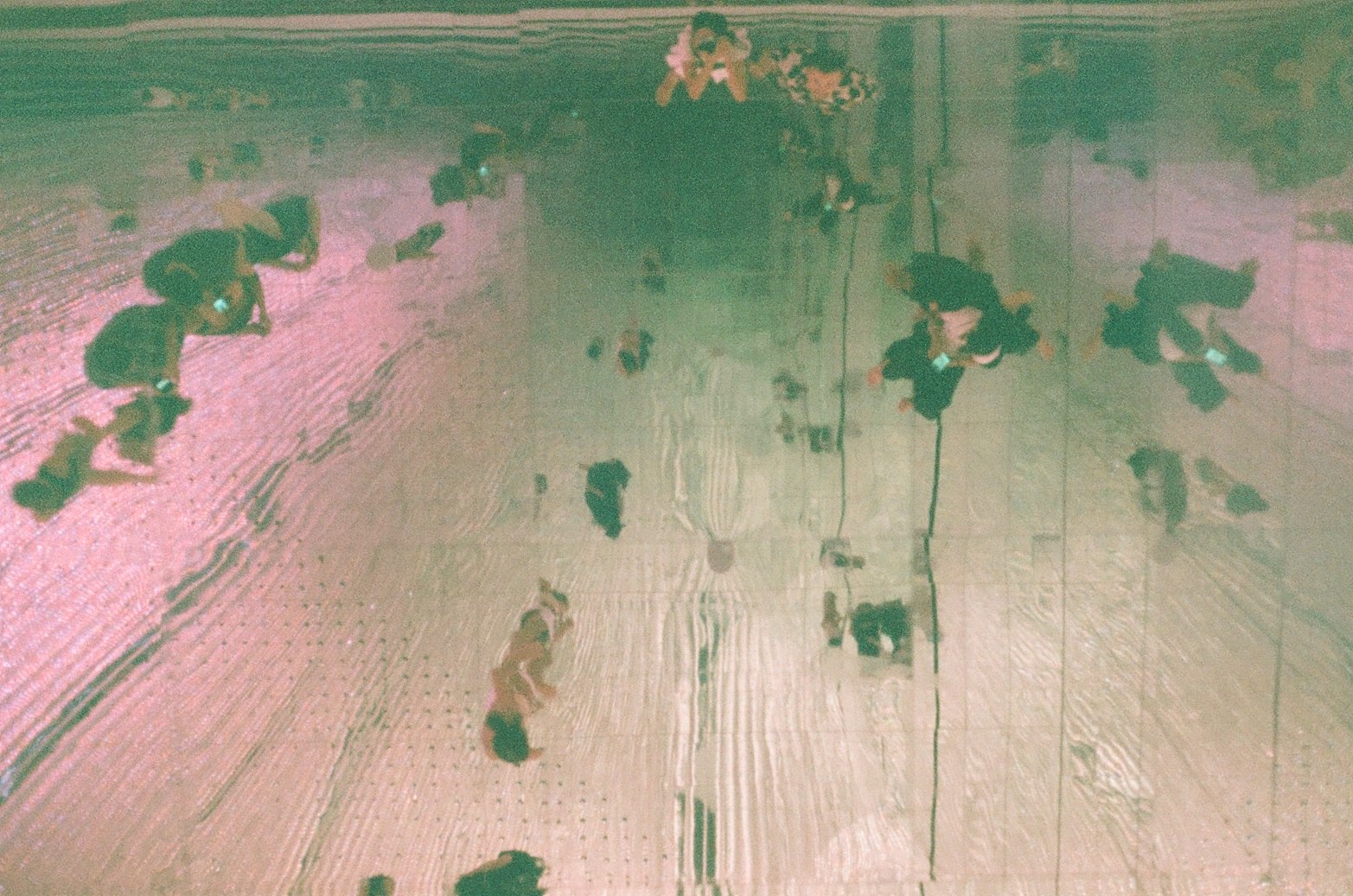 Reflection of people in a car window on a city street